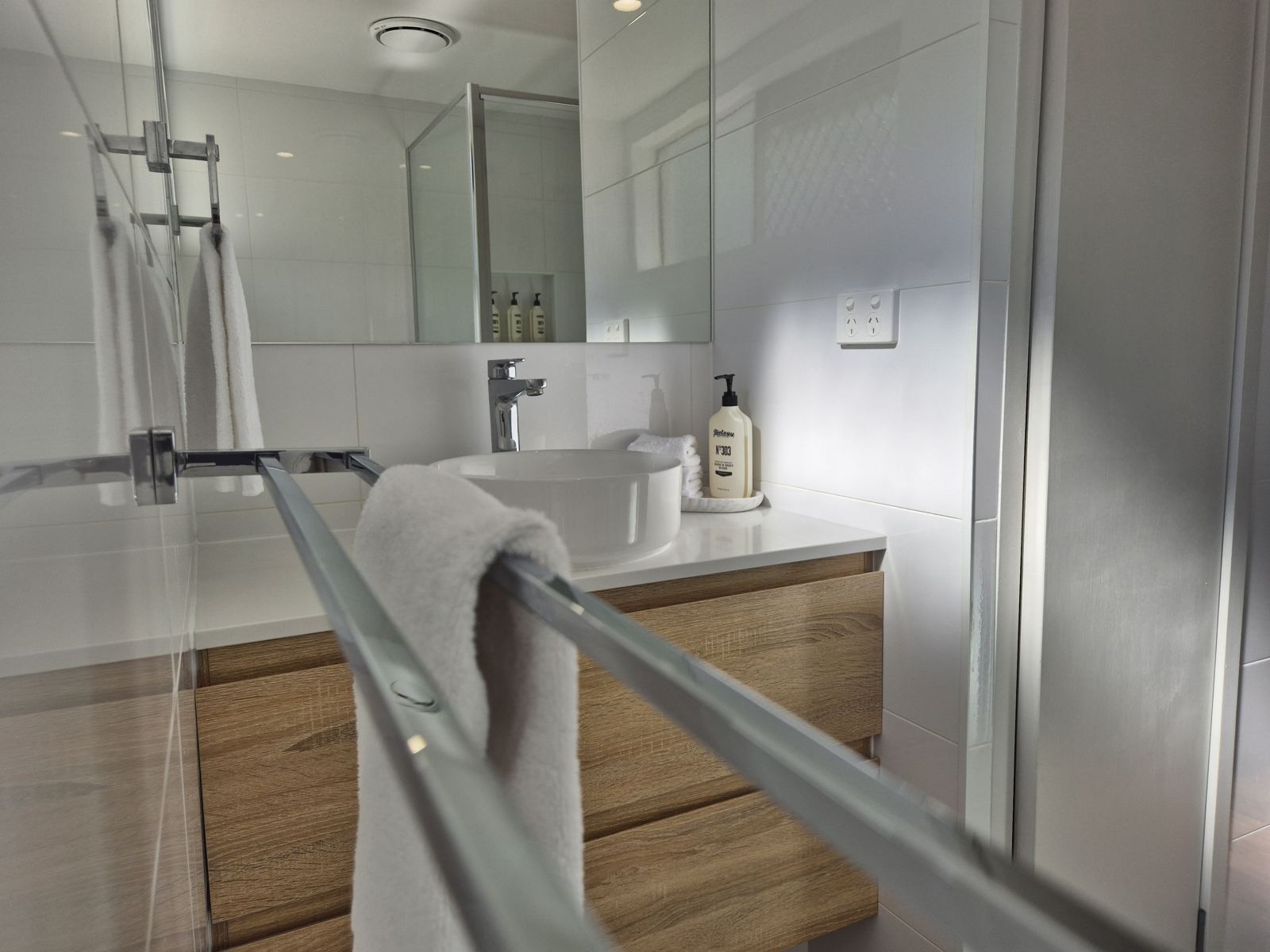 Renovated bathroom with timber vanity, glass shower screen and Biology hand and body wash