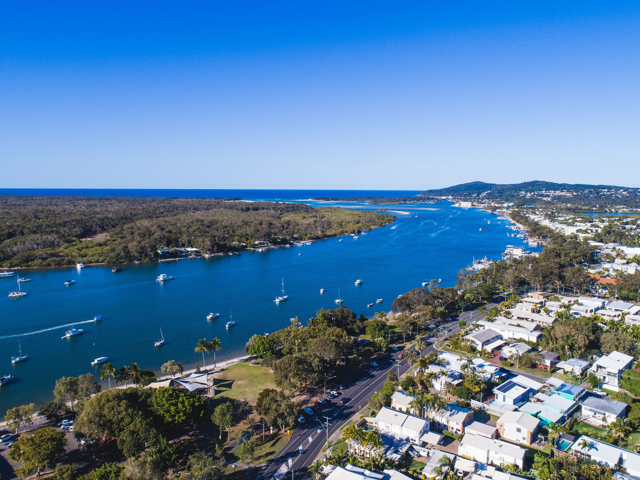 Aerial view along Gympie Terrace and the Noosa River, with Noosa Heads and the river mouth in the distance